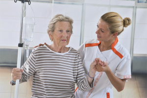 Nurse walking next to a patient with IV drip in hospital
