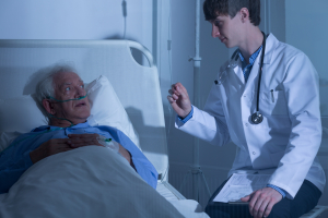 Doctor and elderly patient in hospice care ward